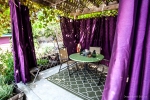Gazebo with purple curtains, a table and chairs
