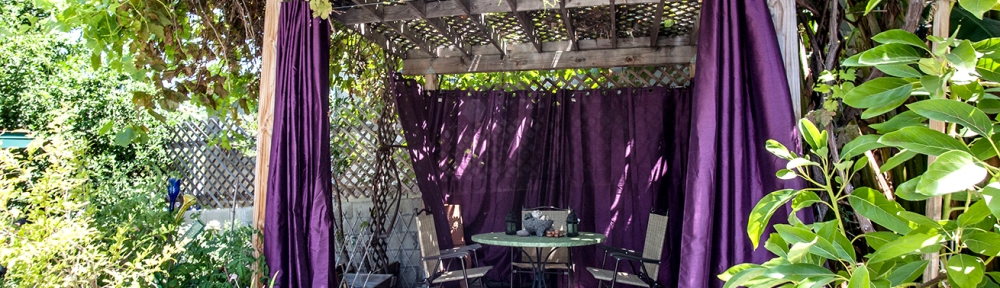 Gazebo with purple curtains, a table and chairs